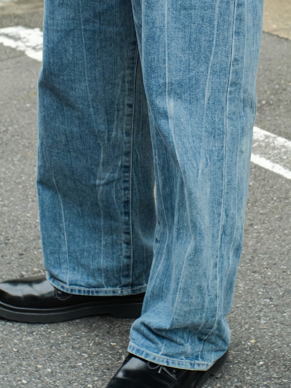 ブルー系のニット/セーター、ブルー系のデニムパンツ、ブラック系のドレスシューズを着用したメンズの秋コーディネートの4枚目の写真
