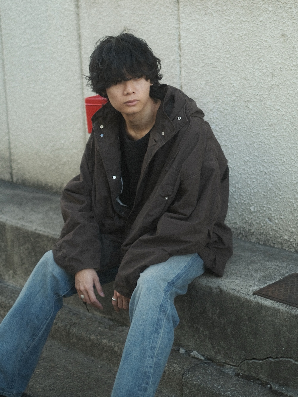 ブラウン系のブルゾン、ブラック系のTシャツ/カットソー、ブルー系のデニムパンツを着用したメンズの冬コーディネートの2枚目の写真