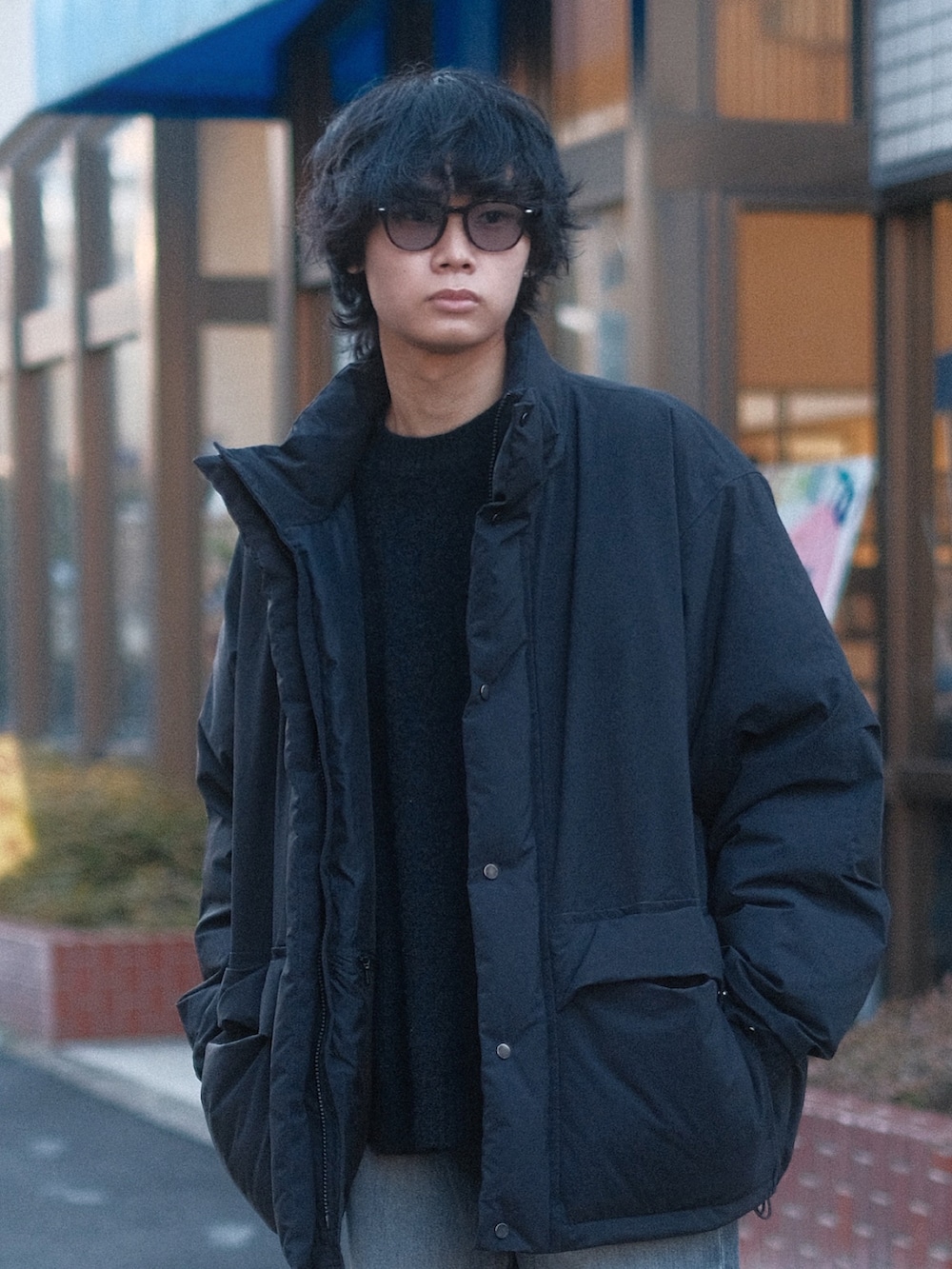 ブラック系のダウンジャケット/コート、グレー系のデニムパンツ、ブラック系のスニーカーを着用したメンズの冬コーディネートの2枚目の写真