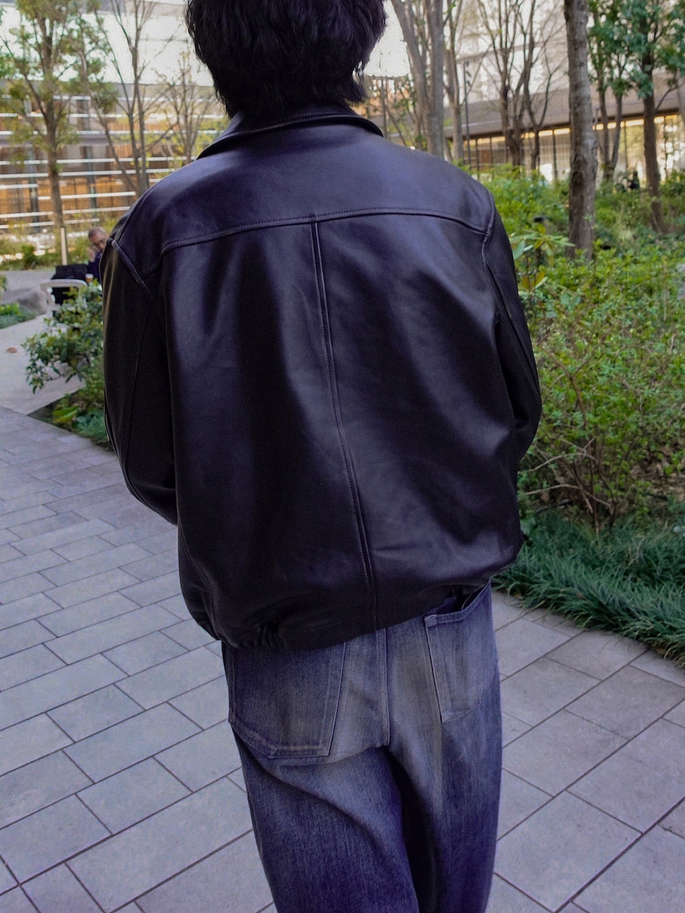 ブラック系のブーツ、ブラック系のブルゾン、ブルー系のデニムパンツを着用したメンズの春コーディネートの3枚目の写真