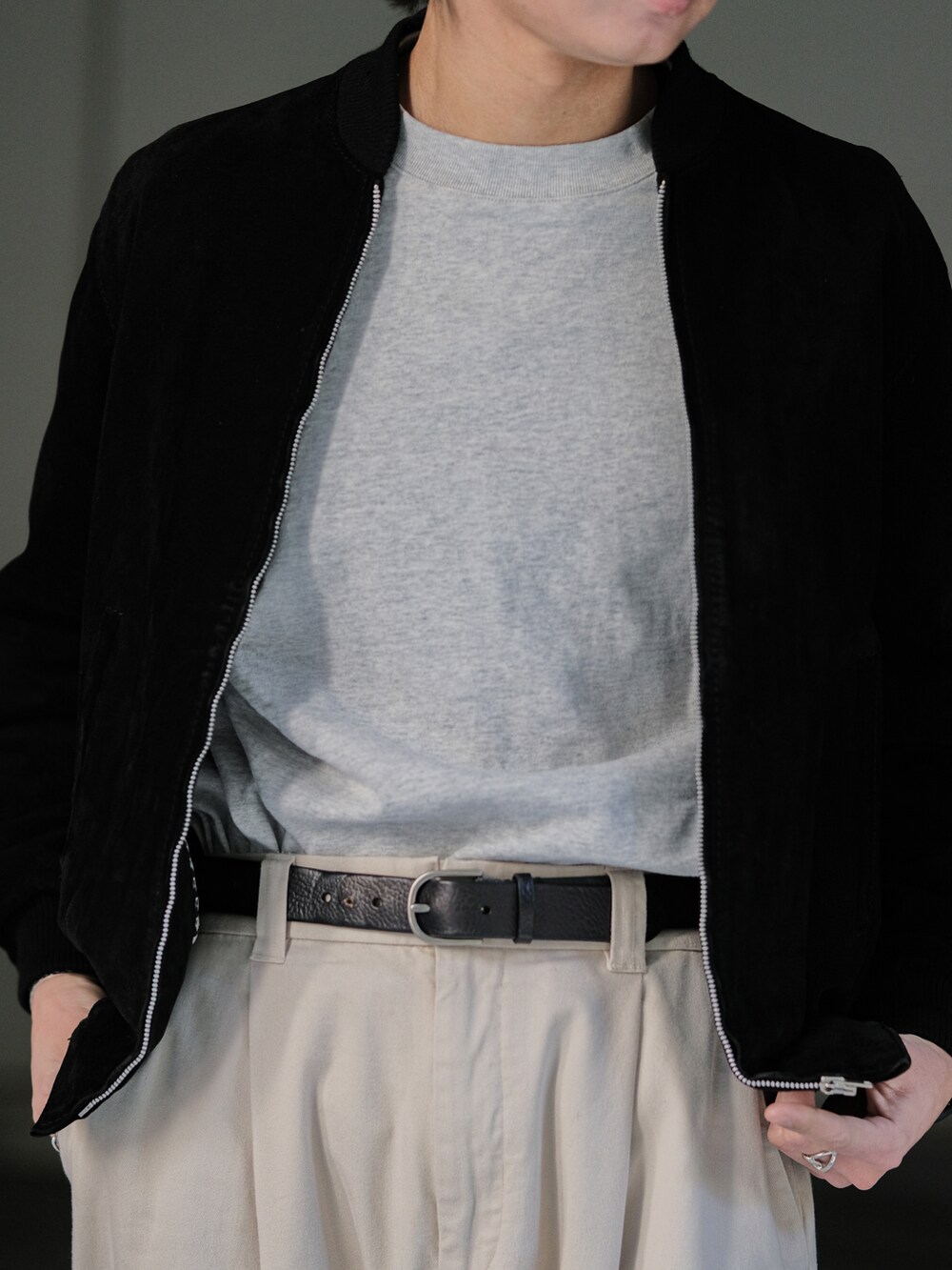 ブラック系のブルゾン、グレー系のTシャツ/カットソー、ホワイト系のその他パンツを着用したメンズの春コーディネートの3枚目の写真