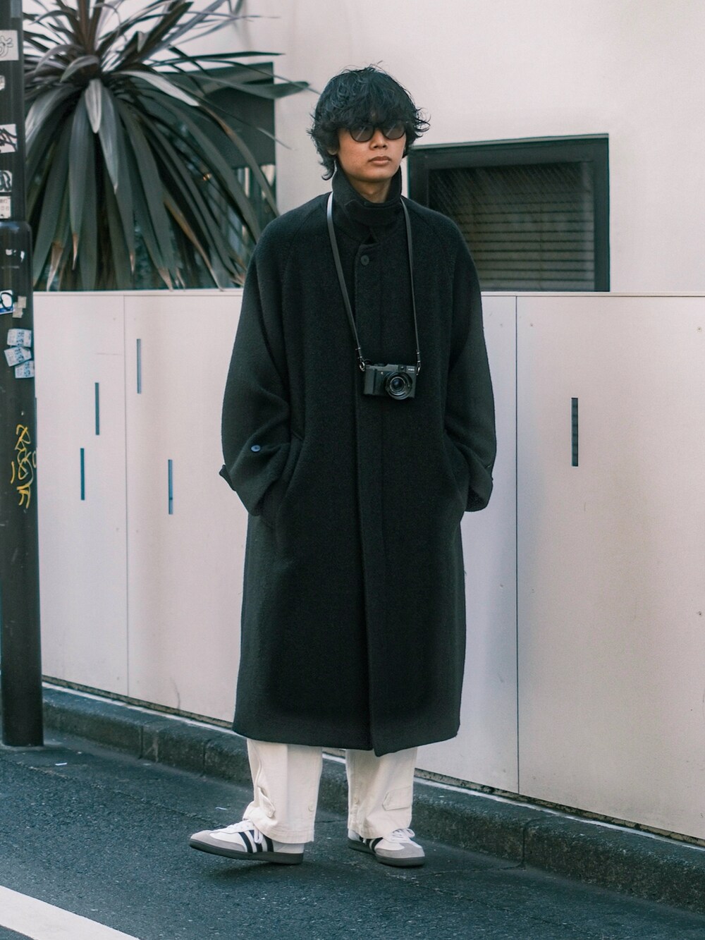 ブラック系のその他アウター、ホワイト系のスニーカー、ホワイト系のカーゴパンツを着用したメンズの冬コーディネートの2枚目の写真