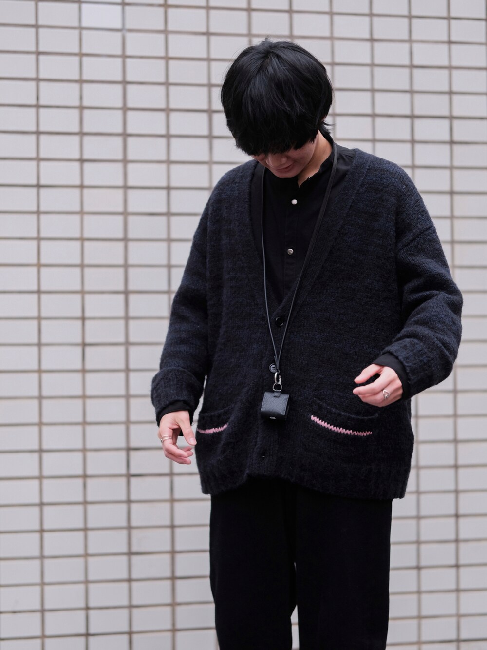 ブラック系のカーディガン/ボレロ、ブラック系のミリタリージャケット、ブラック系のデニムパンツを着用したメンズの冬コーディネートの2枚目の写真