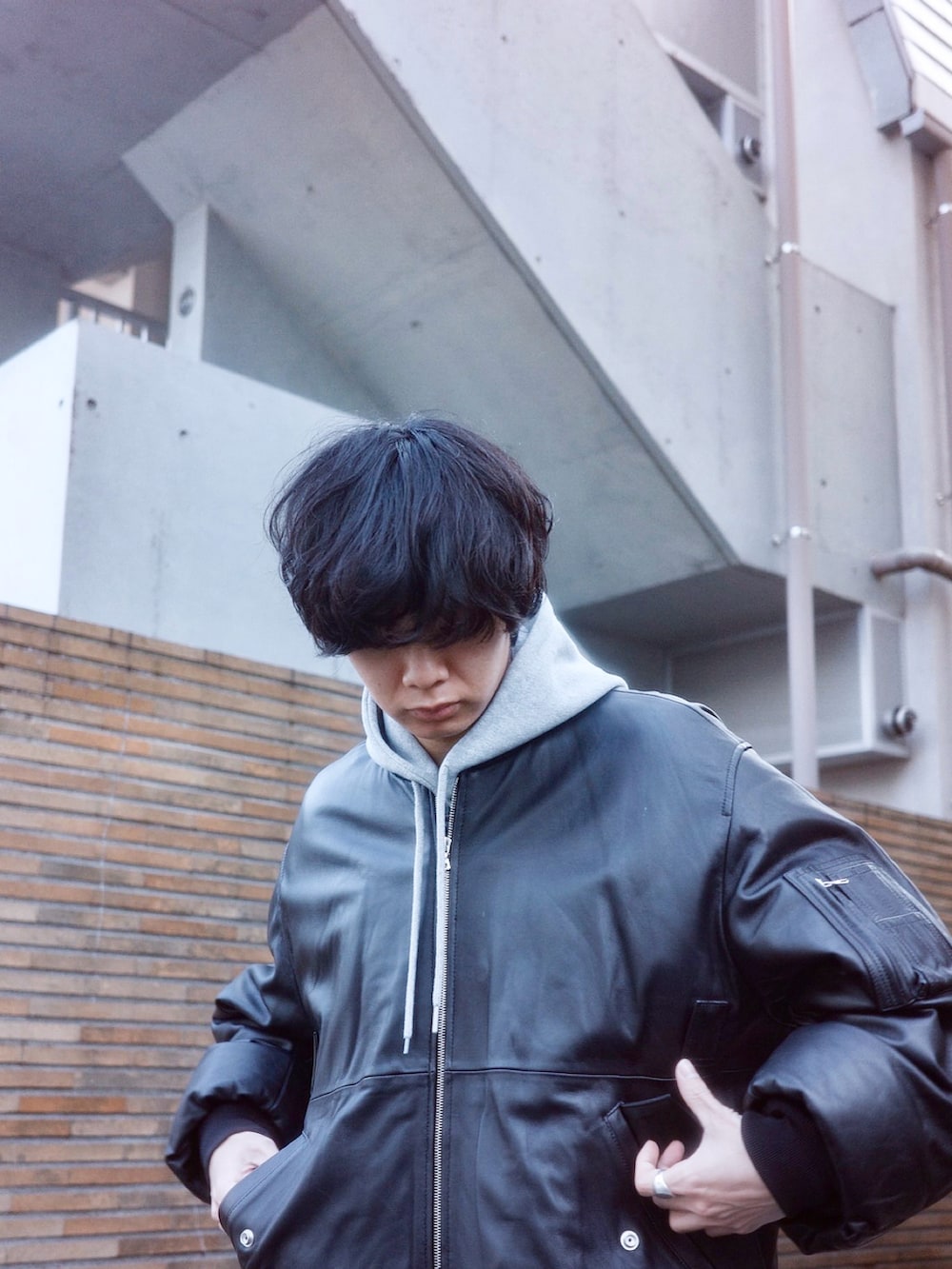 ブラック系のブルゾン、グレー系のパーカー、グレー系のスウェットパンツを着用したメンズの冬コーディネートの4枚目の写真