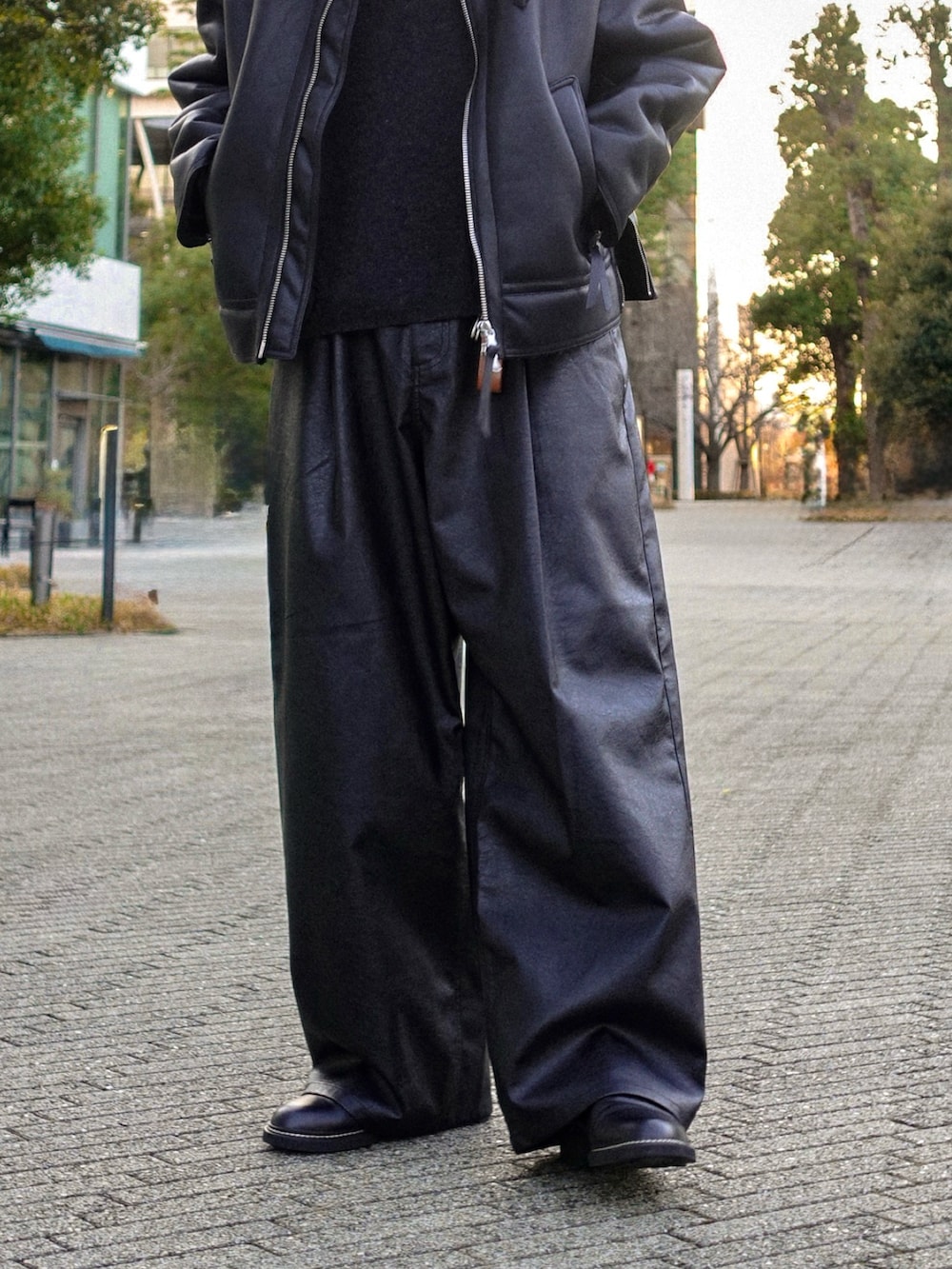 ブラック系のブルゾン、ブラック系のスラックス、ブラック系のドレスシューズを着用したメンズの冬コーディネートの3枚目の写真