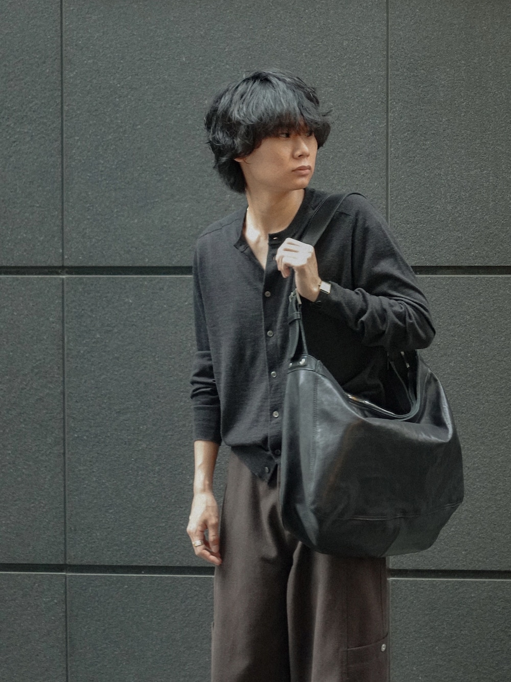 ブラック系のブーツ、ブラック系のカーディガン/ボレロ、ブラウン系のカーゴパンツを着用したメンズの春コーディネートの3枚目の写真
