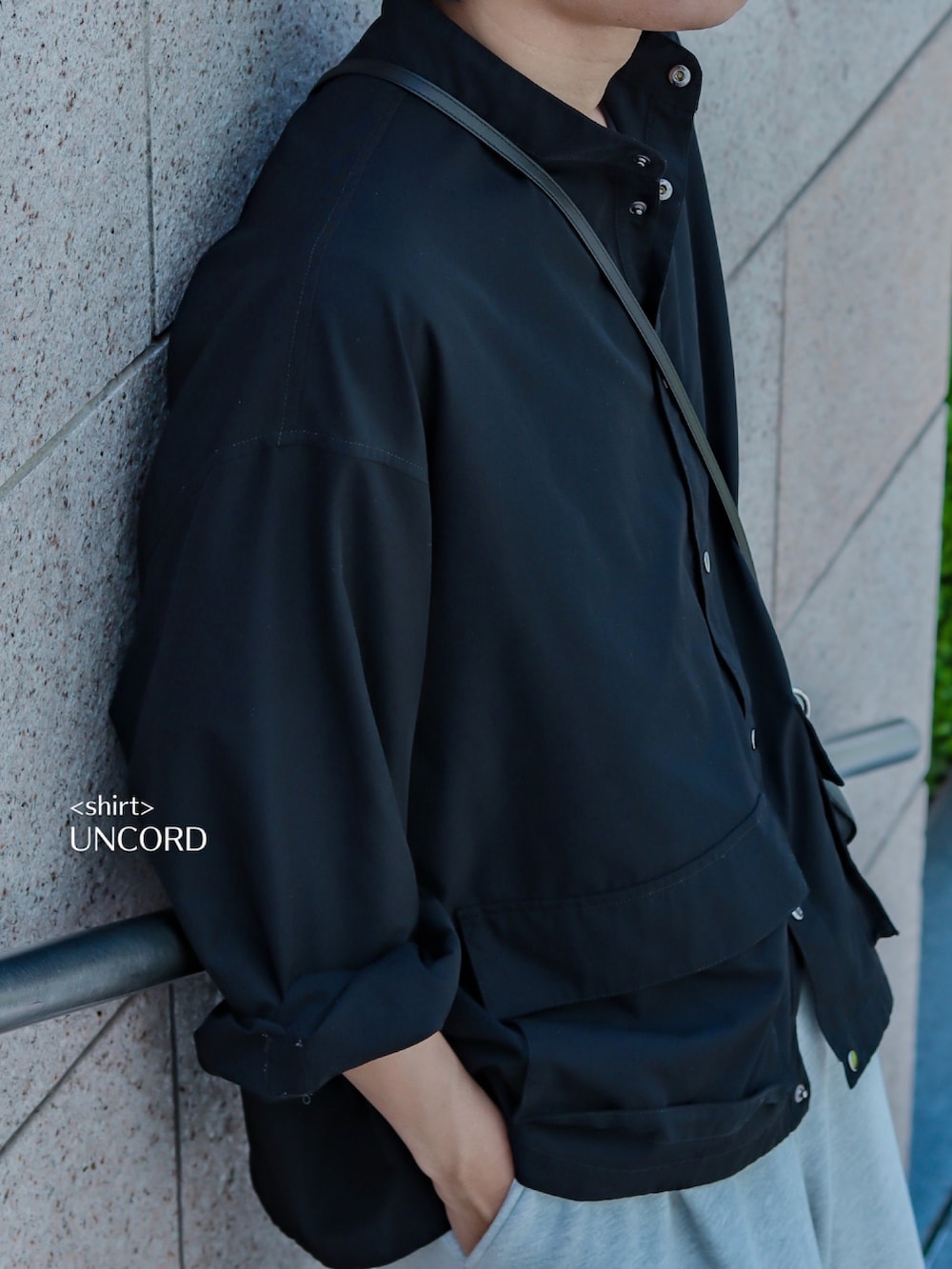 ブラック系のミリタリージャケット、グレー系のスウェットパンツ、ホワイト系のスニーカーを着用したメンズの春コーディネートの5枚目の写真