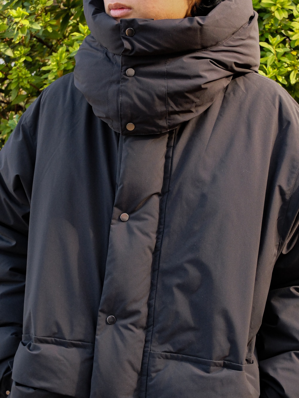 ブラック系のニット/セーター、ブラック系のダウンジャケット/コート、ブルー系のデニムパンツを着用したメンズの冬コーディネートの2枚目の写真