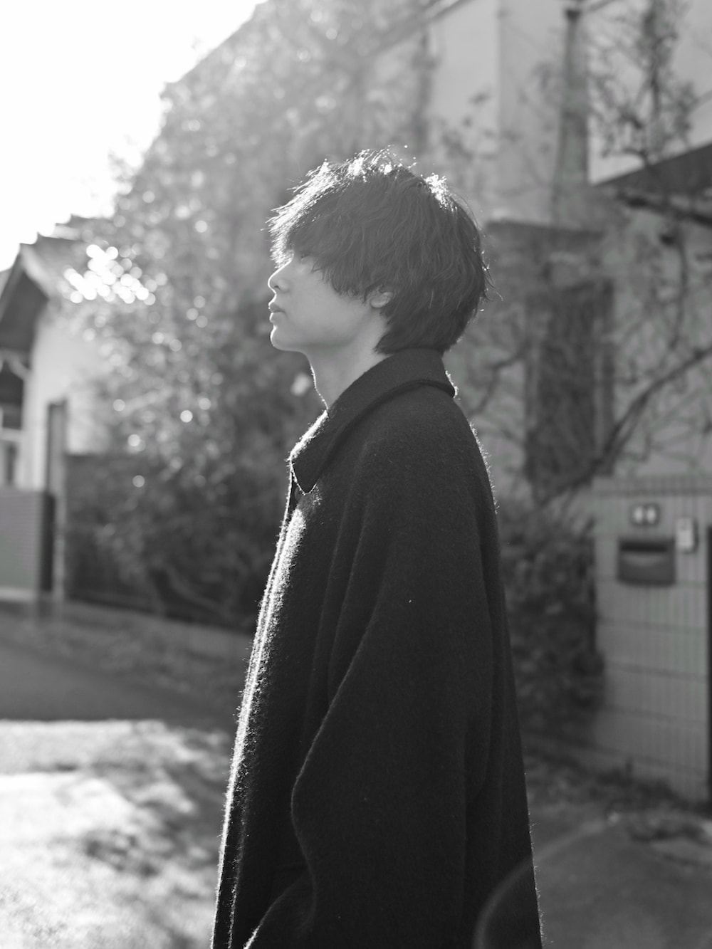 ブラック系のブーツ、ブラック系のその他アウター、ブラウン系のニット/セーターを着用したメンズの冬コーディネートの2枚目の写真