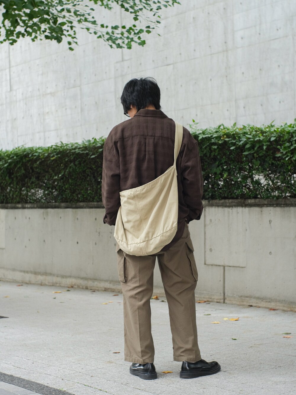 ブラウン系のシャツ/ブラウス、ベージュ系のメッセンジャーバッグ、グリーン系のカーゴパンツを着用したメンズの秋コーディネートの4枚目の写真