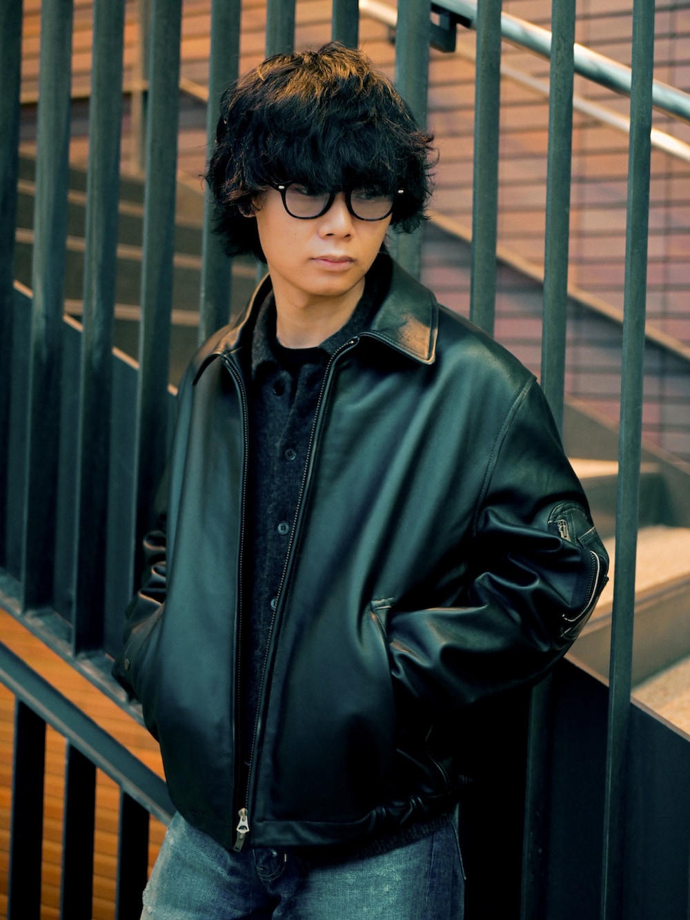 ブラック系のカーディガン/ボレロ、ブラック系のブルゾン、ブラック系のブーツを着用したメンズの春コーディネートの2枚目の写真