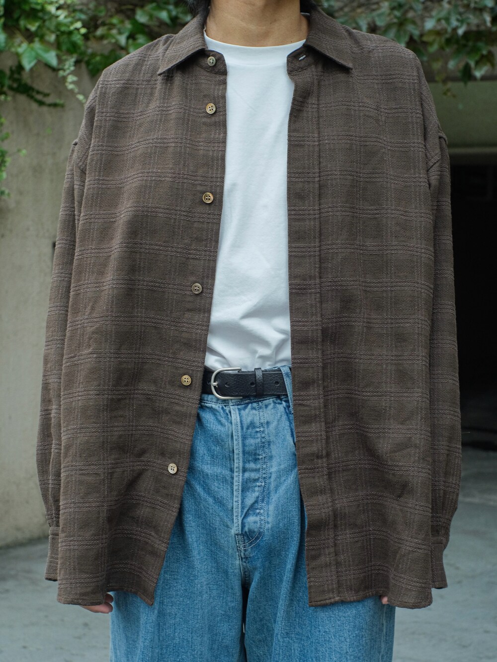 ブラウン系のシャツ/ブラウス、ブルー系のデニムパンツ、ホワイト系のTシャツ/カットソーを着用したメンズの秋コーディネートの3枚目の写真