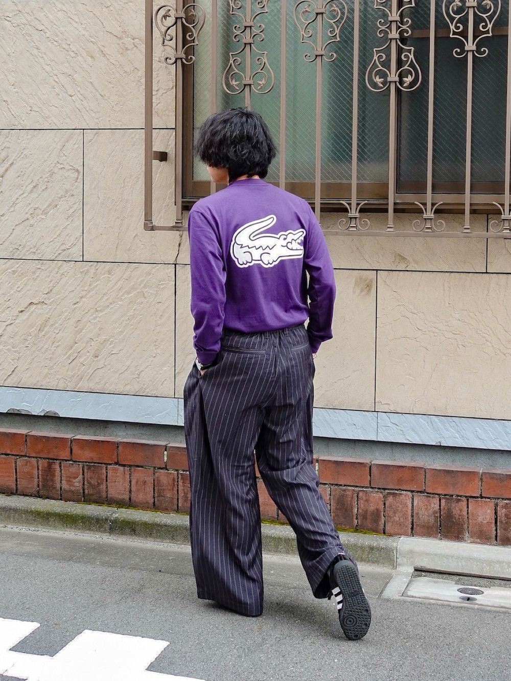 パープル系のTシャツ/カットソー、グレー系のスラックス、ブラック系のアナログ腕時計を着用したメンズの秋コーディネートの2枚目の写真