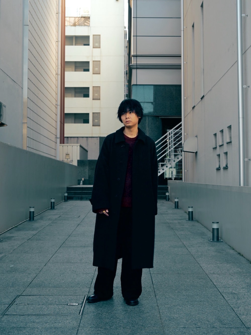 ブラック系のブーツ、ブラック系のその他アウター、ブラウン系のニット/セーターを着用したメンズの冬コーディネートの3枚目の写真