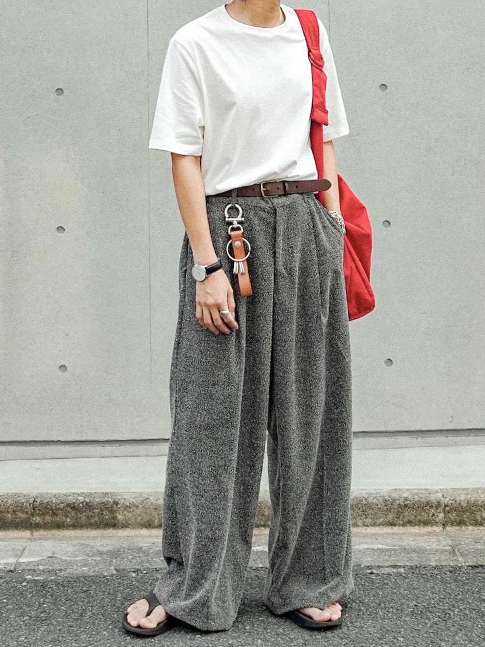 ホワイト系のTシャツ/カットソー、グレー系のスラックス、ブラック系のサンダルを着用したメンズの夏コーディネートの2枚目の写真