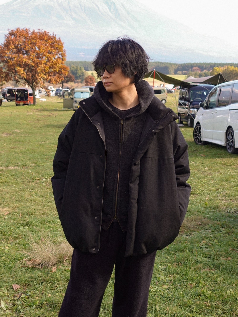 ブラック系のパーカー、ブラック系のTシャツ/カットソー、ブラック系のダウンジャケット/コートを着用したメンズの秋コーディネートの3枚目の写真