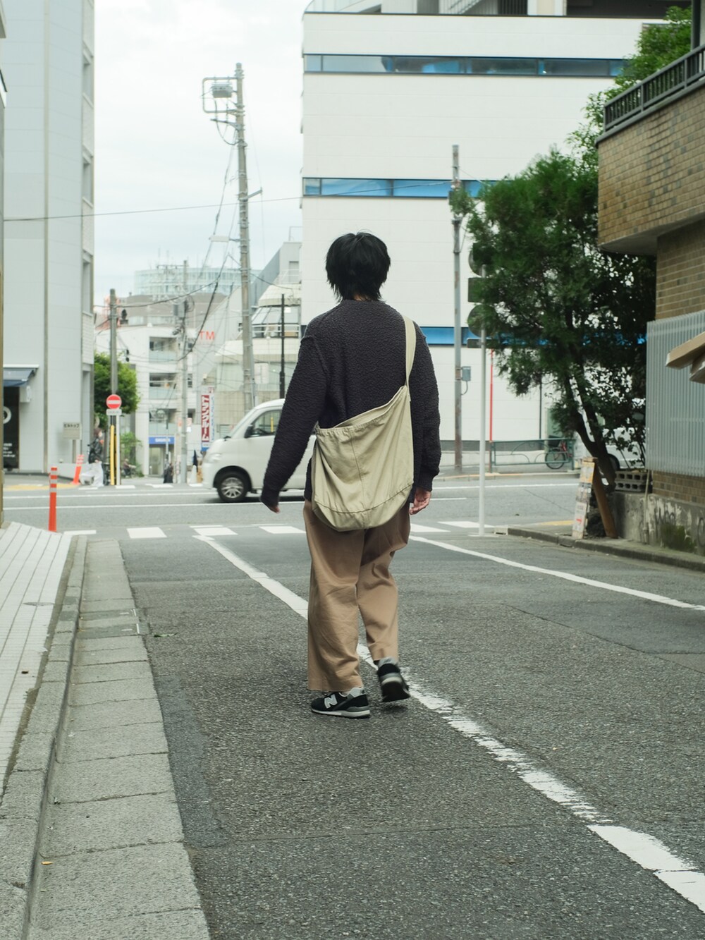 ブルー系のニット/セーター、ベージュ系のメッセンジャーバッグ、ベージュ系のその他パンツを着用したメンズの秋コーディネートの4枚目の写真