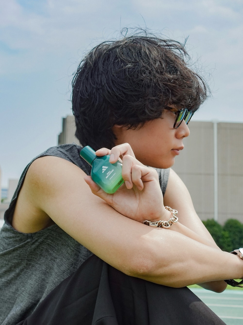 グレー系のタンクトップ、ブラック系のスラックス、ブラック系のスニーカーを着用したメンズの夏コーディネートの3枚目の写真