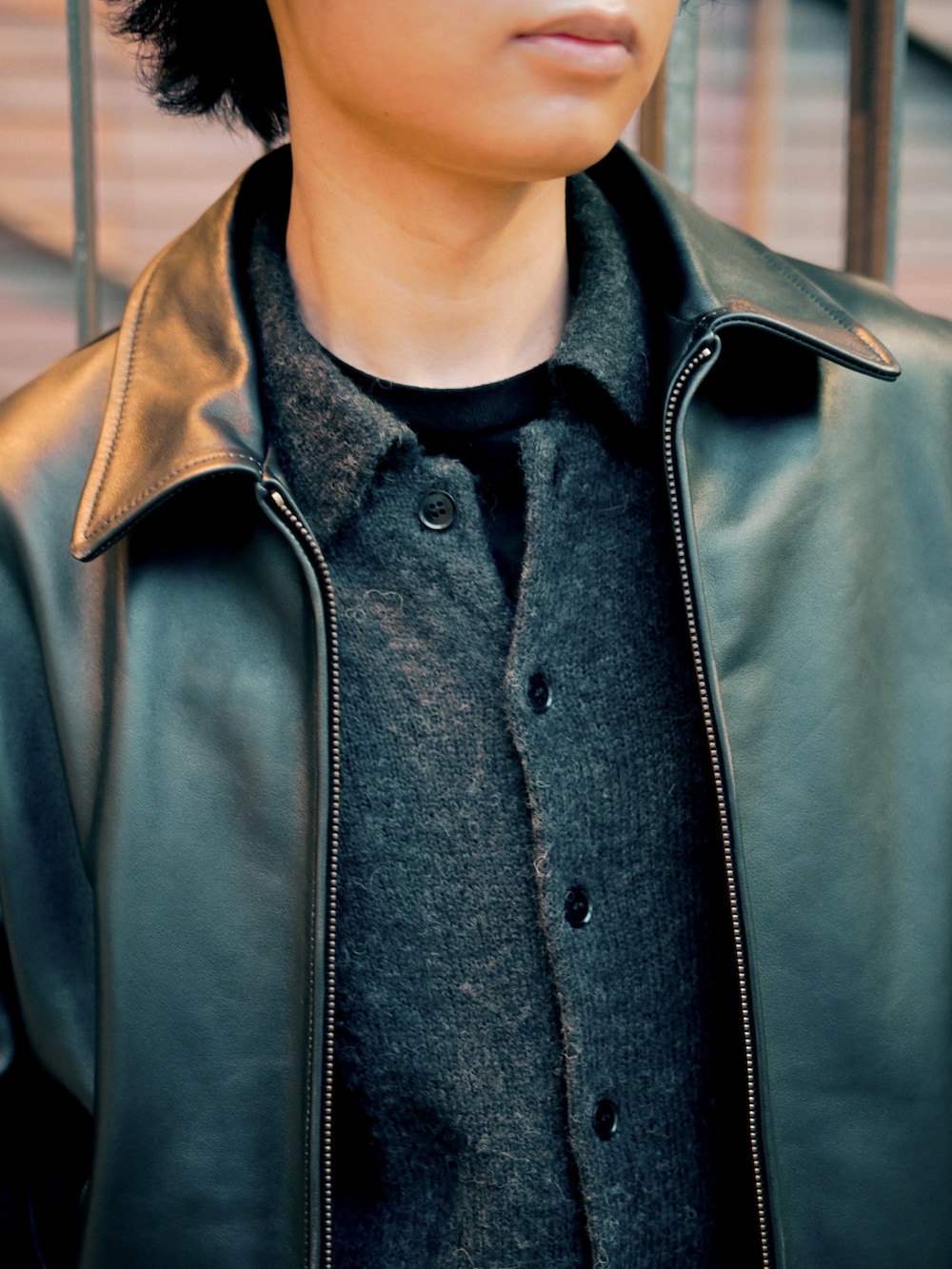 ブラック系のカーディガン/ボレロ、ブラック系のブルゾン、ブラック系のブーツを着用したメンズの春コーディネートの3枚目の写真