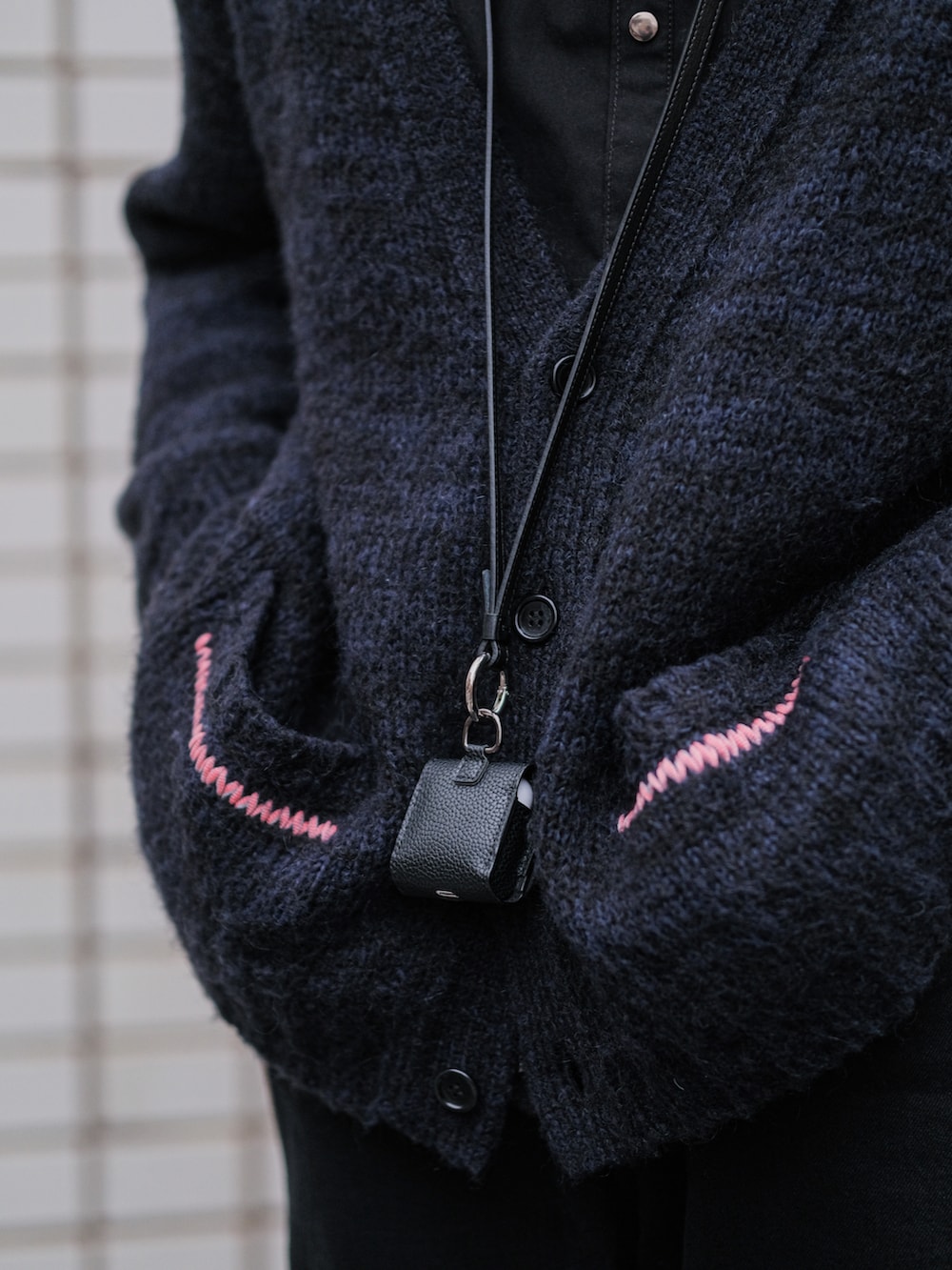 ブラック系のカーディガン/ボレロ、ブラック系のミリタリージャケット、ブラック系のデニムパンツを着用したメンズの冬コーディネートの3枚目の写真