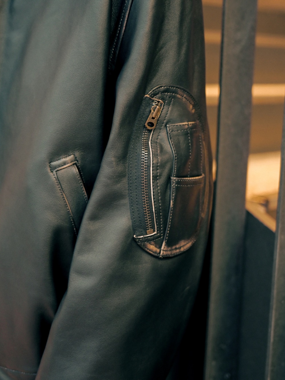 ブラック系のカーディガン/ボレロ、ブラック系のブルゾン、ブラック系のブーツを着用したメンズの春コーディネートの4枚目の写真