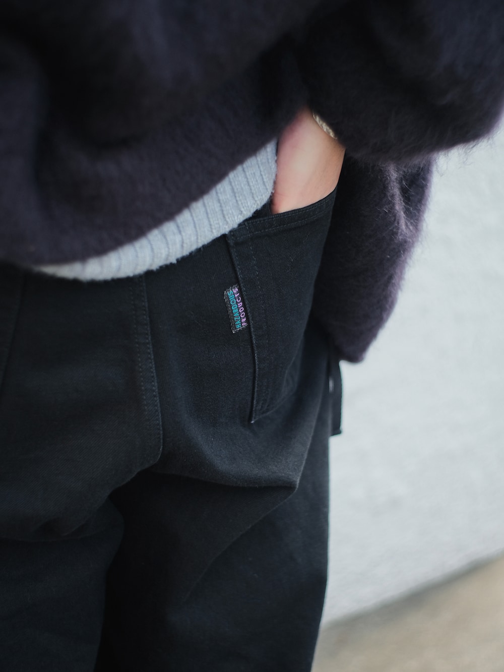 ブルー系のブルゾン、グレー系のニット/セーター、ブラック系のデニムパンツを着用したメンズの冬コーディネートの3枚目の写真