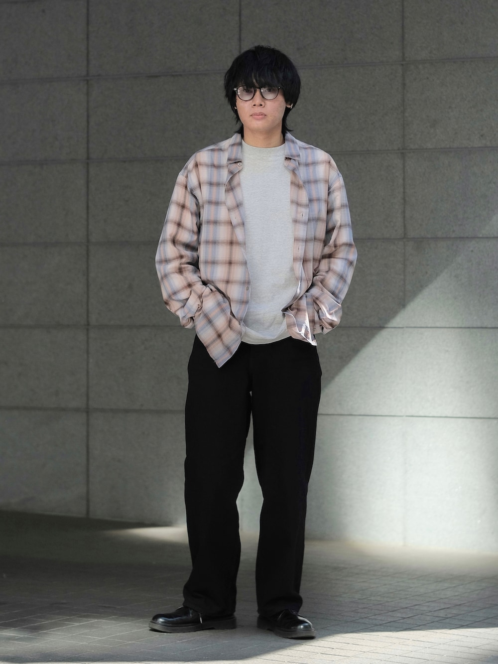 オレンジ系のシャツ/ブラウス、グレー系のTシャツ/カットソー、ブラック系のデニムパンツを着用したメンズの春コーディネートの2枚目の写真