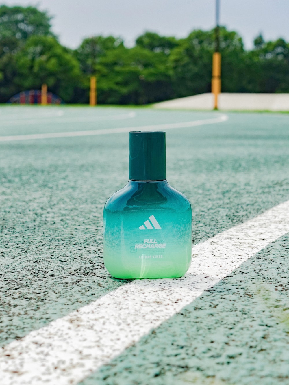 グレー系のタンクトップ、ブラック系のスラックス、ブラック系のスニーカーを着用したメンズの夏コーディネートの4枚目の写真