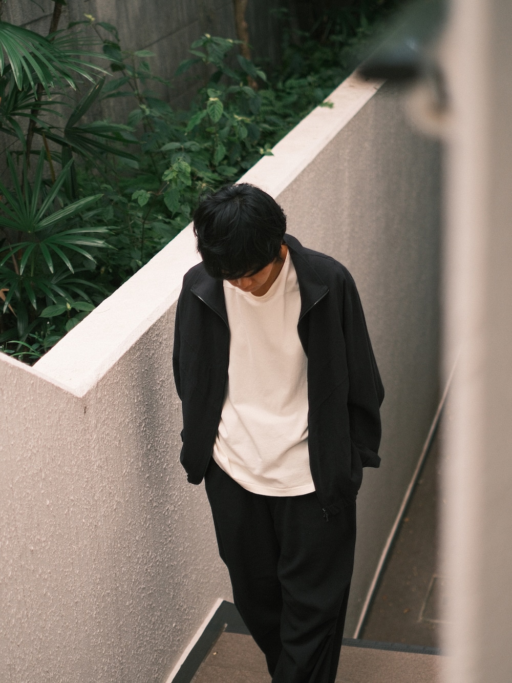 ホワイト系のTシャツ/カットソー、ブラック系のその他アウター、ブラック系のその他パンツを着用したメンズの秋コーディネートの2枚目の写真