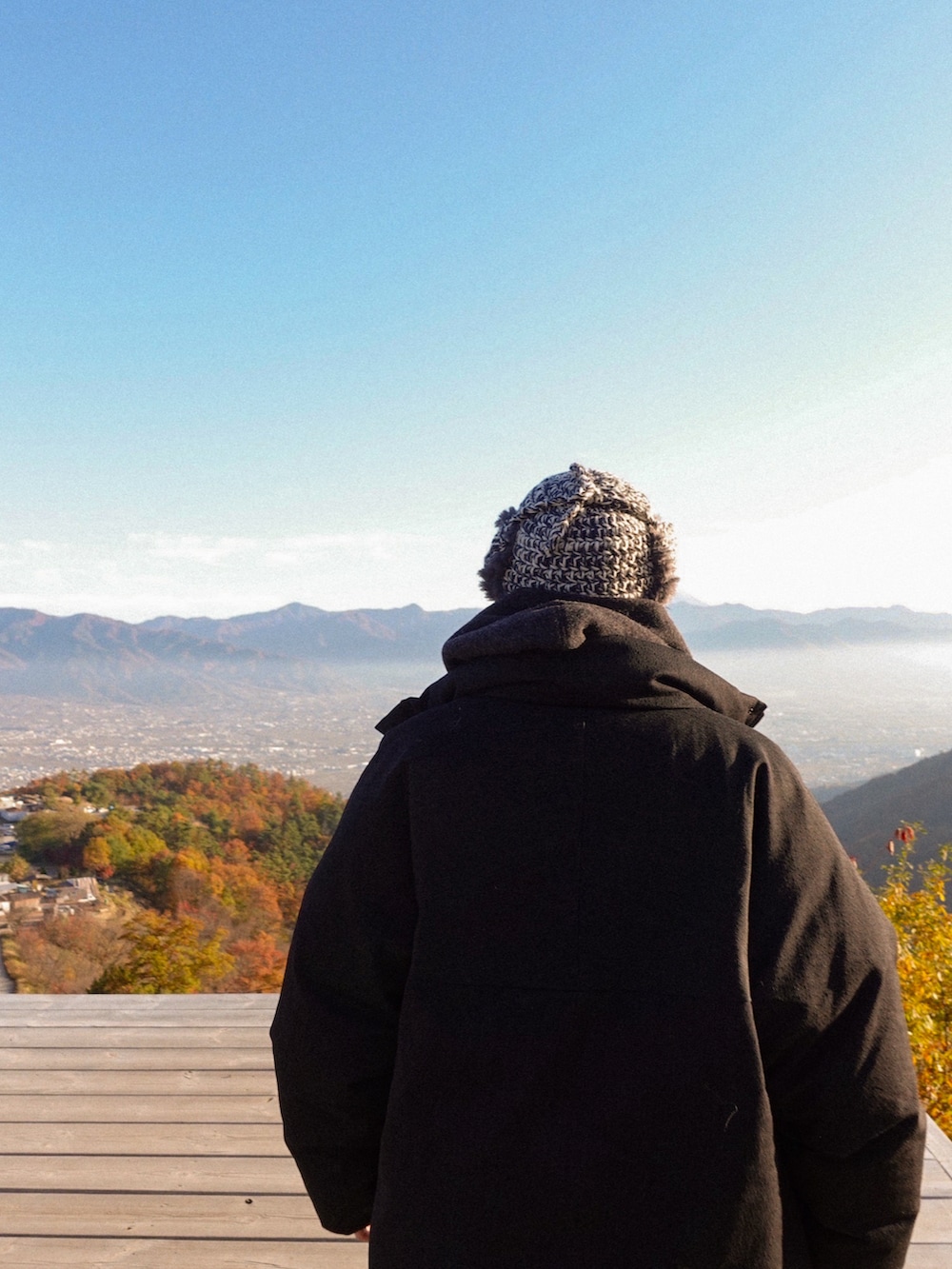 ブラック系のパーカー、ブラック系のダウンジャケット/コート、ブラック系のスニーカーを着用したメンズの秋コーディネートの3枚目の写真