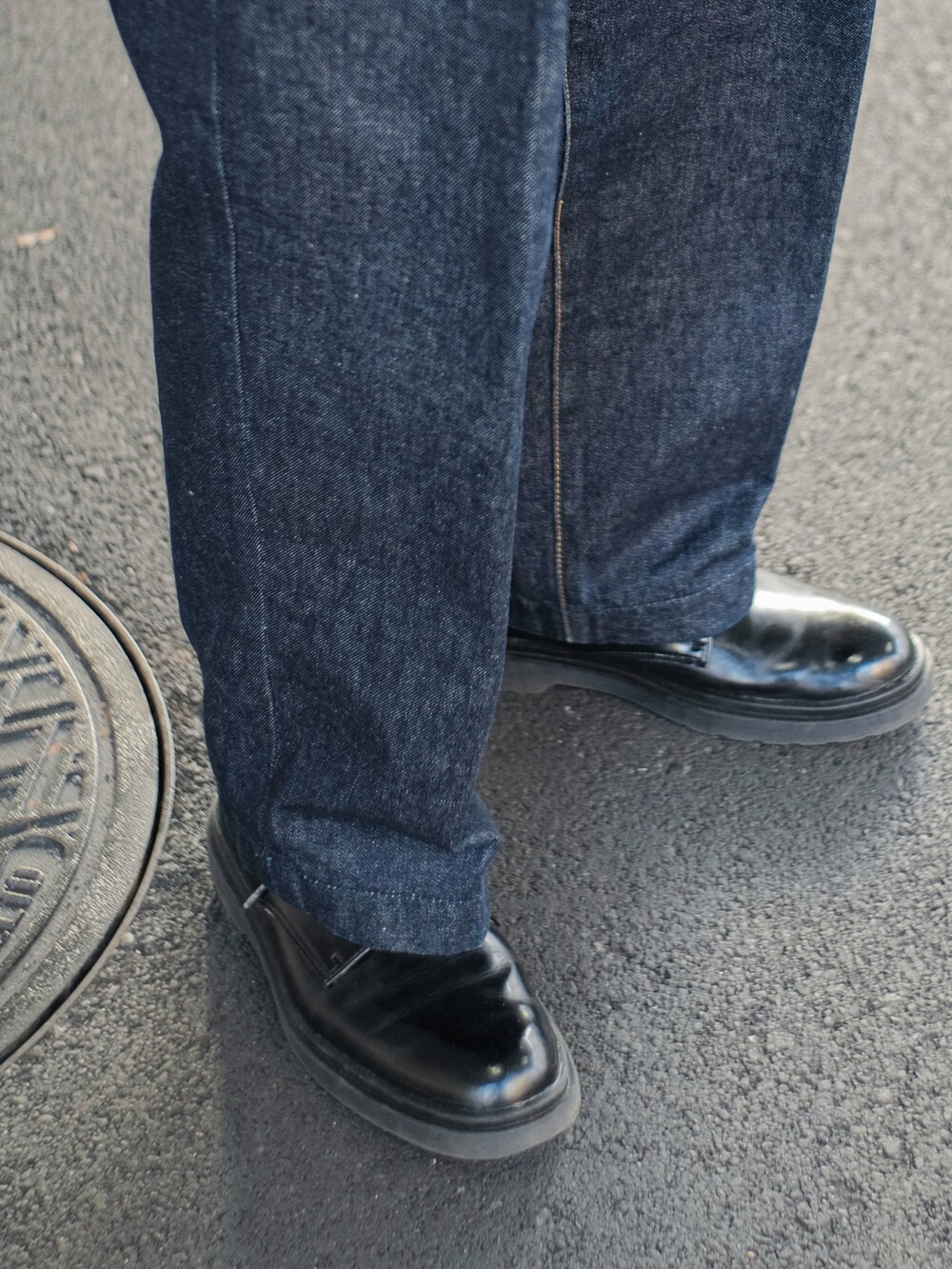 グレー系のニット/セーター、ブルー系のデニムパンツ、ブラック系のドレスシューズを着用したメンズの冬コーディネートの4枚目の写真