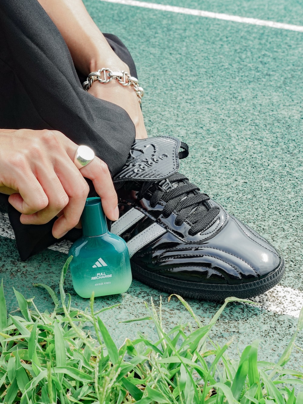 グレー系のタンクトップ、ブラック系のスラックス、ブラック系のスニーカーを着用したメンズの夏コーディネートの2枚目の写真