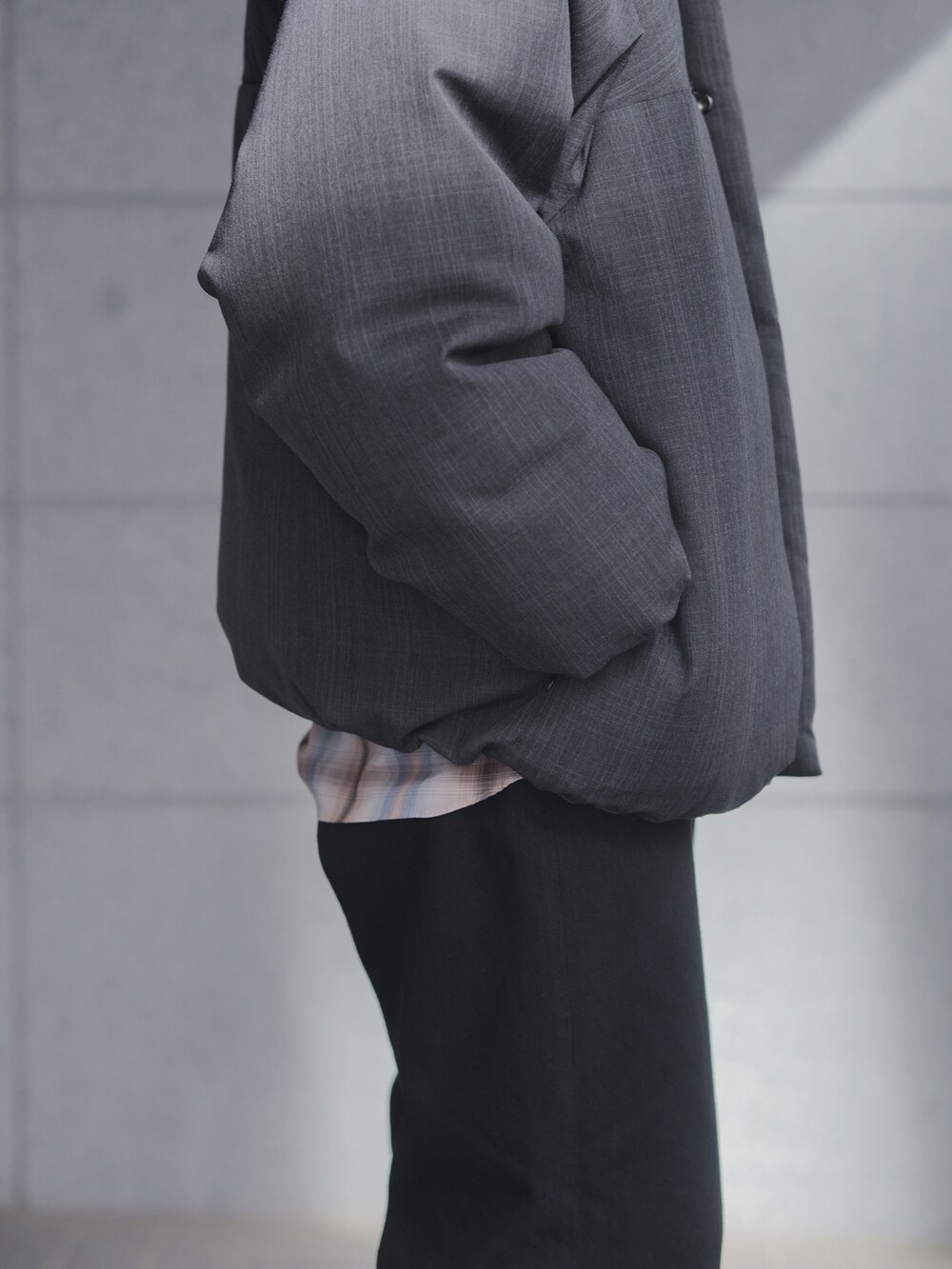 グレー系のダウンジャケット/コート、ブラック系のデニムパンツ、ブラック系のドレスシューズを着用したメンズの冬コーディネートの4枚目の写真