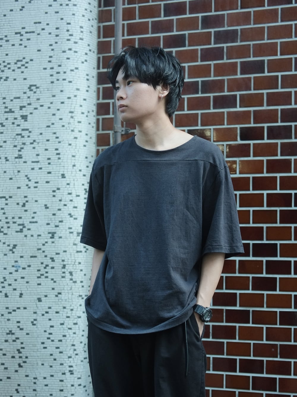 ブラック系のTシャツ/カットソー、ブラック系のパンツ、ブラック系のサンダルを着用したメンズの夏コーディネートの3枚目の写真