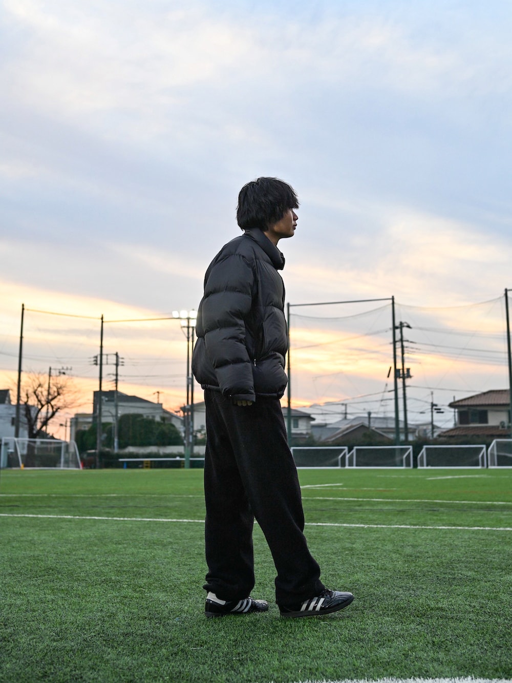 ブラック系のスニーカー、ブラック系のニット/セーター、ブラック系のダウンジャケット/コートを着用したメンズの冬コーディネートの2枚目の写真