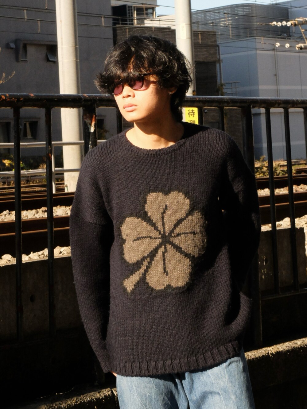 ブルー系のニット/セーター、ブルー系のデニムパンツ、ブラック系のスニーカーを着用したメンズの冬コーディネートの2枚目の写真