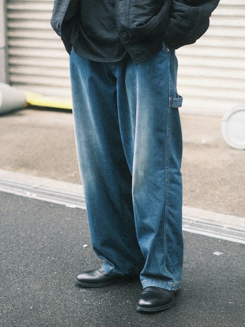 ブルー系のデニムパンツ、ブラック系のTシャツ/カットソー、ブラック系のブルゾンを着用したメンズの春コーディネートの2枚目の写真