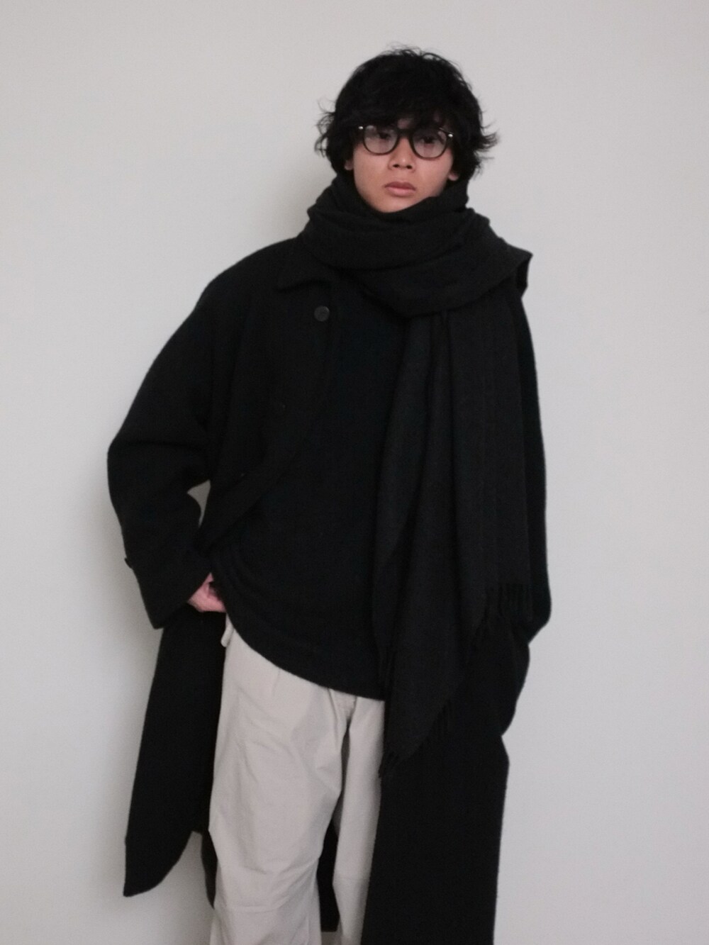 ホワイト系のパンツ、ブラック系のニット/セーター、ブラック系のその他アウターを着用したメンズの冬コーディネートの2枚目の写真