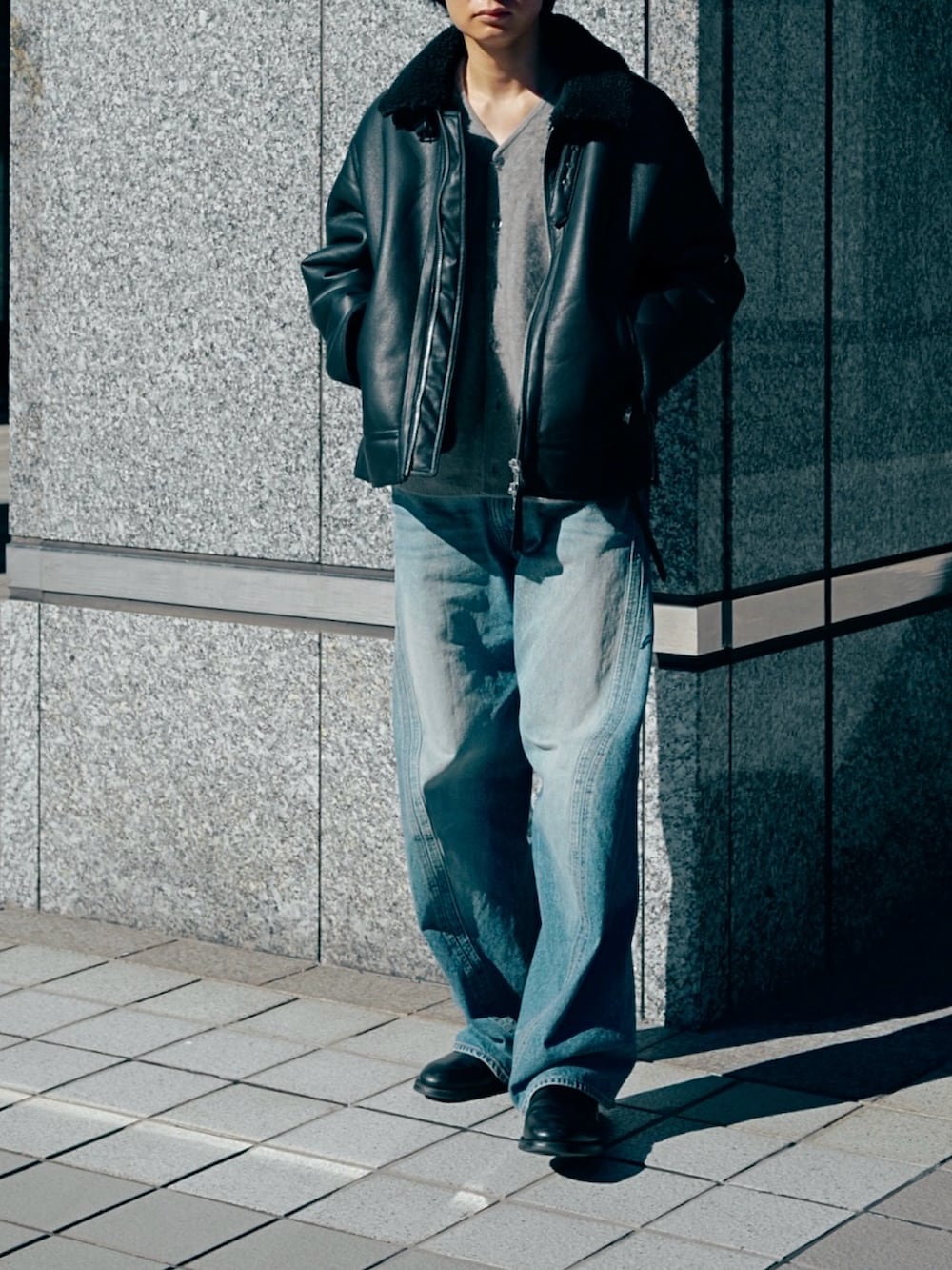 ブラック系のブルゾン、ブラック系のブーツ、ブルー系のデニムパンツを着用したメンズの冬コーディネートの2枚目の写真