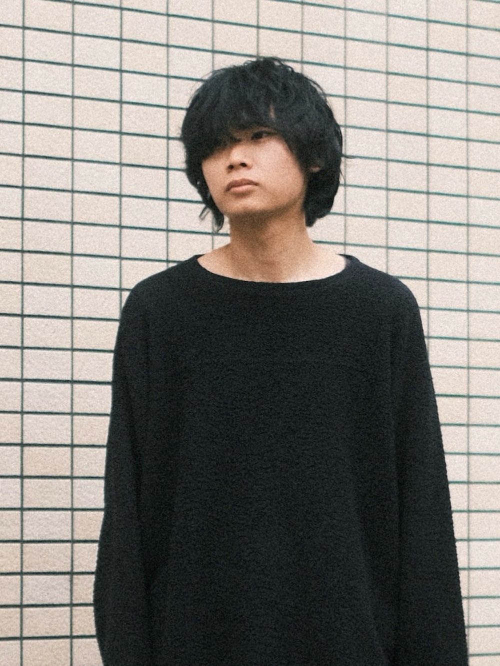 グレー系のデニムパンツ、ブラック系のTシャツ/カットソー、ブラック系のスニーカーを着用したメンズの春コーディネートの2枚目の写真