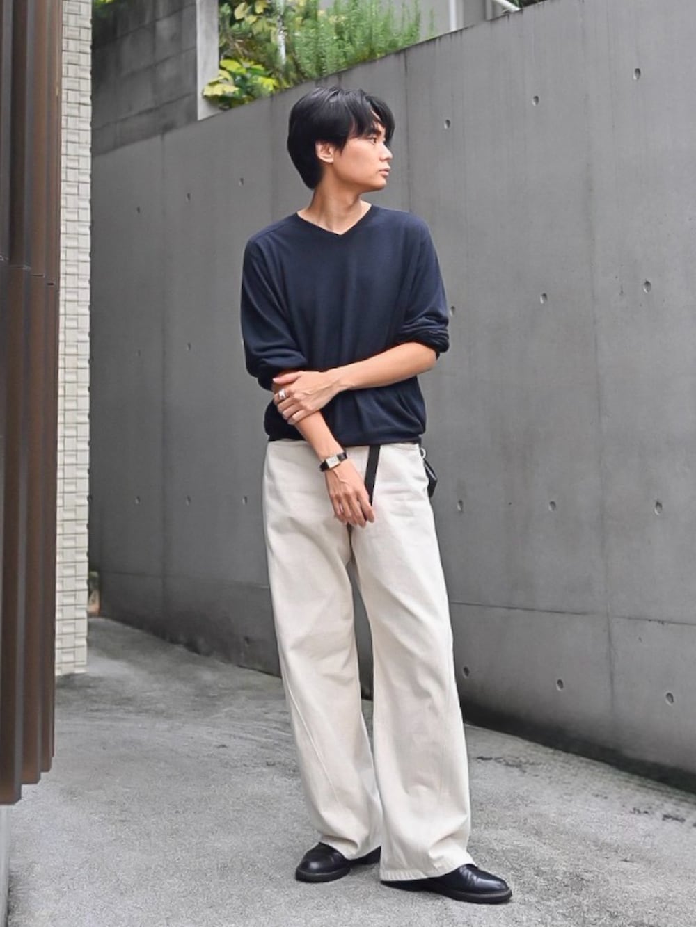ホワイト系のデニムパンツ、ブラック系のドレスシューズ、ブラック系のニット/セーターを着用したメンズの秋コーディネートの2枚目の写真