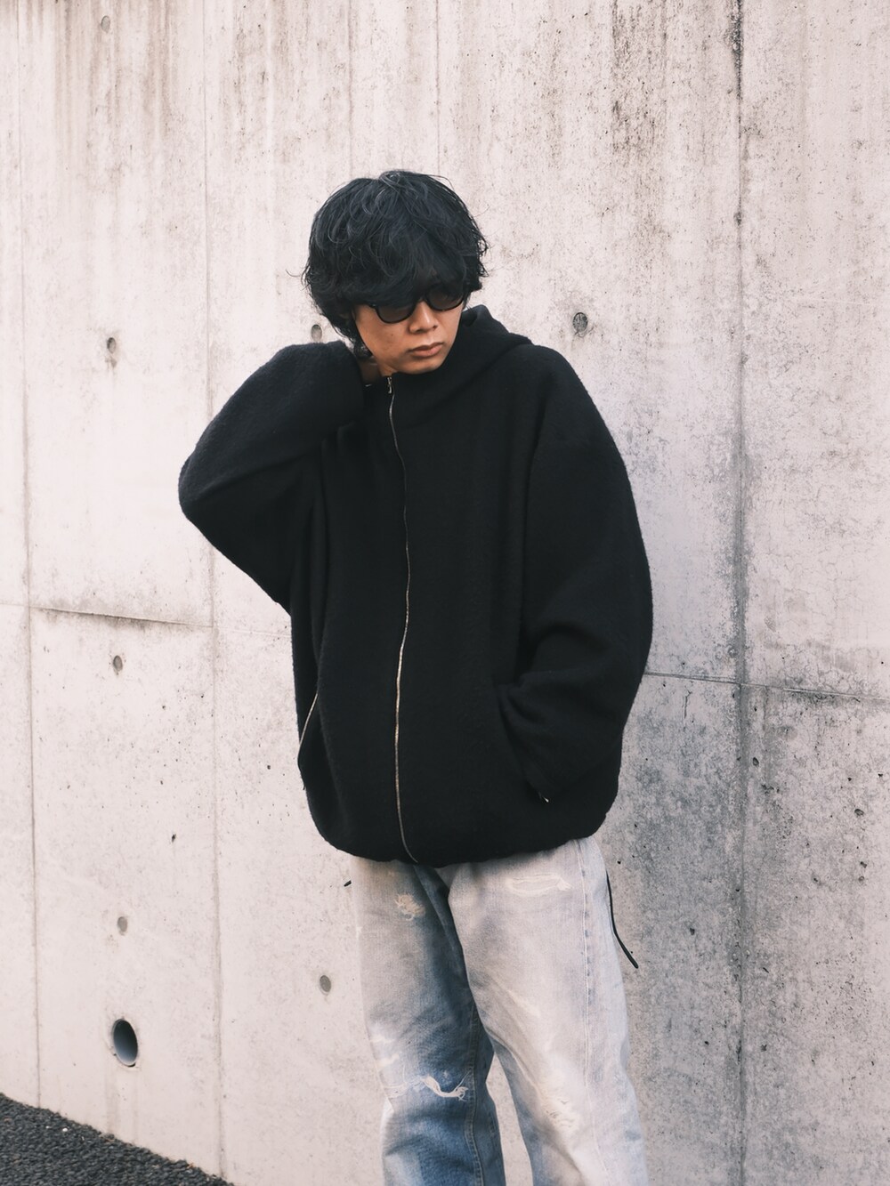 ブラック系のブルゾン、ブルー系のデニムパンツ、ブラック系のスニーカーを着用したメンズの冬コーディネートの2枚目の写真