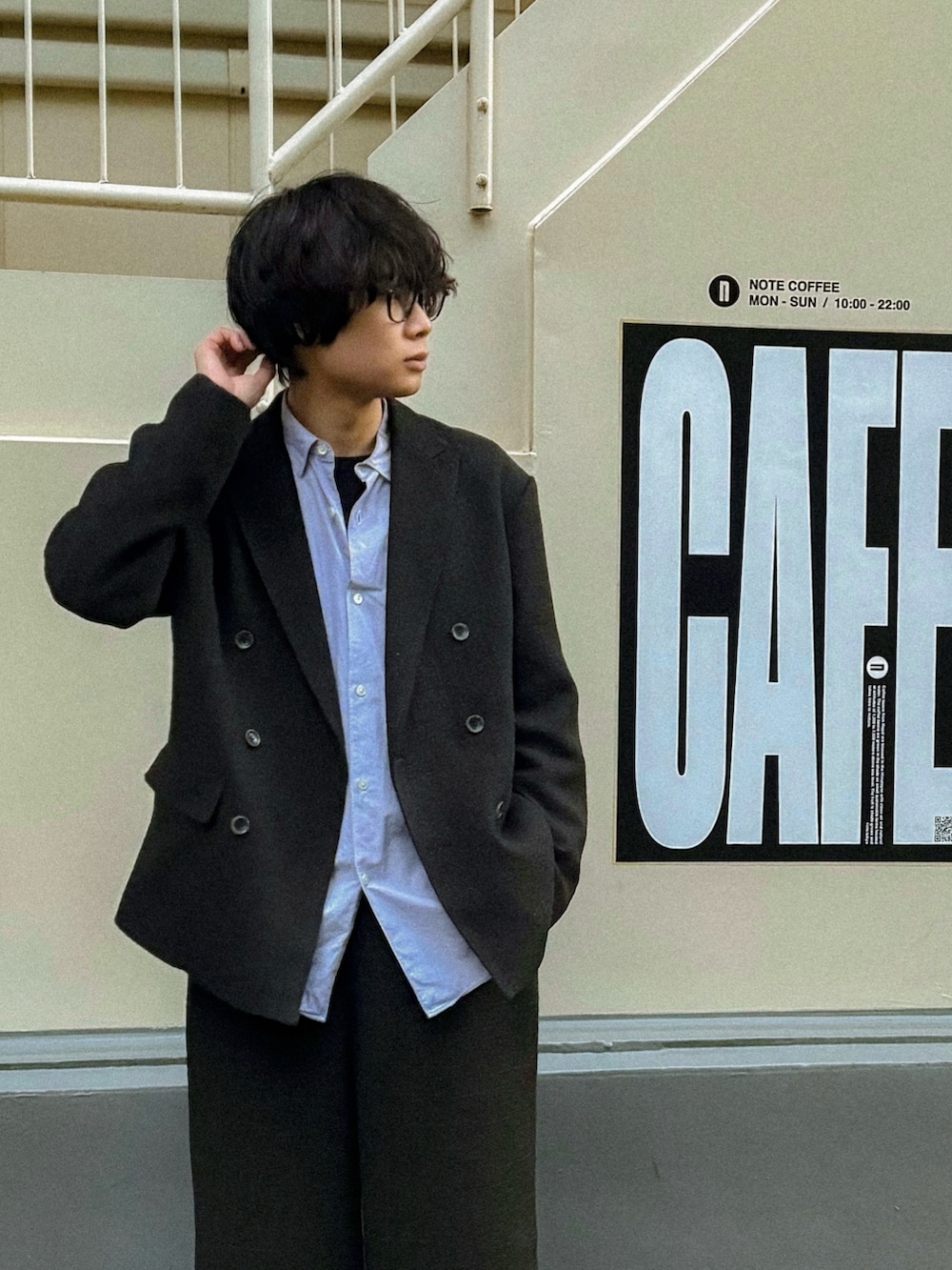 ブラック系のスラックス、ブラック系のテーラードジャケット、ブルー系のシャツ/ブラウスを着用したメンズの春コーディネートの2枚目の写真