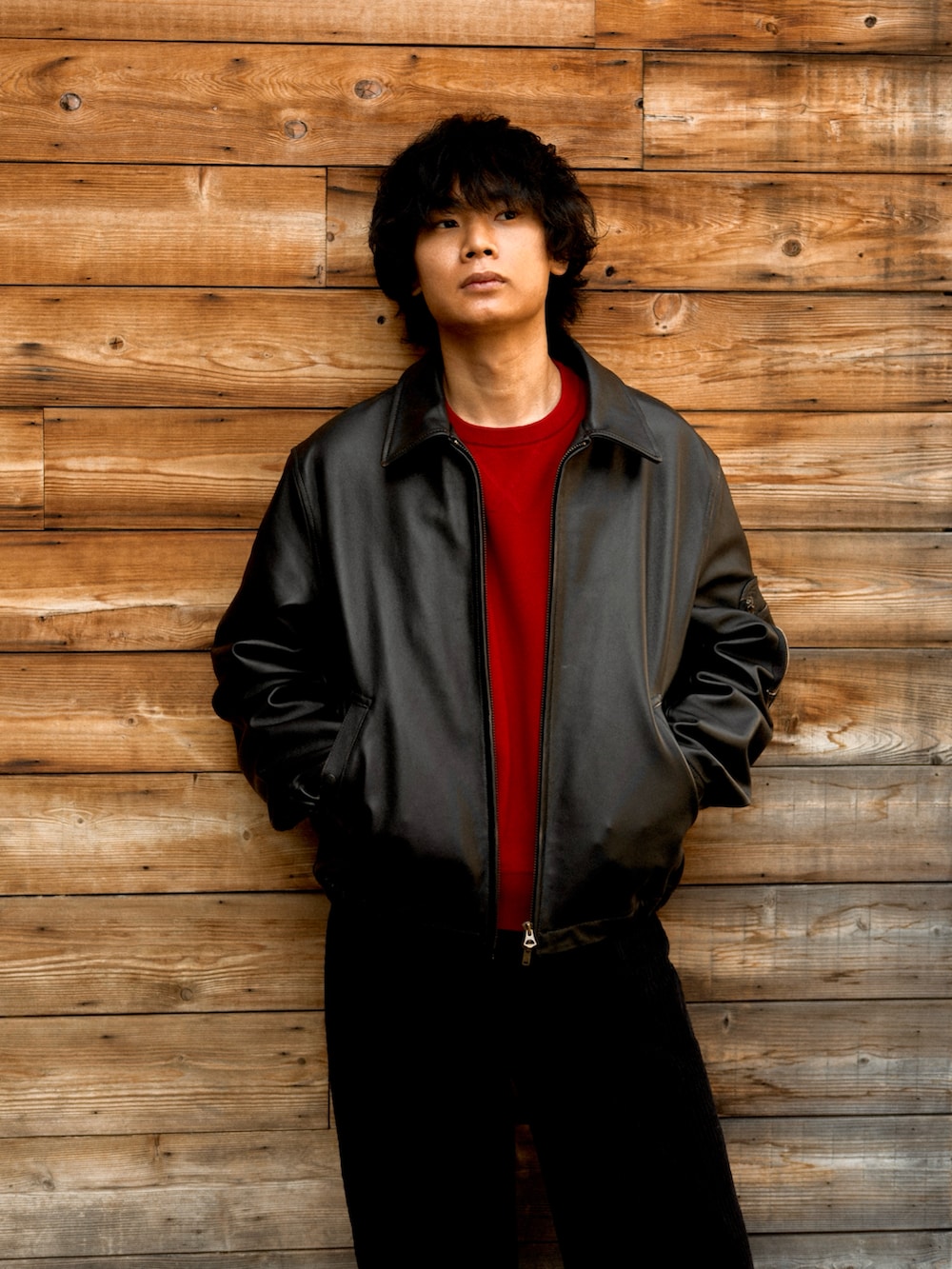 ブラック系のブルゾン、ブラック系のブーツ、レッド系のニット/セーターを着用したメンズの春コーディネートの2枚目の写真