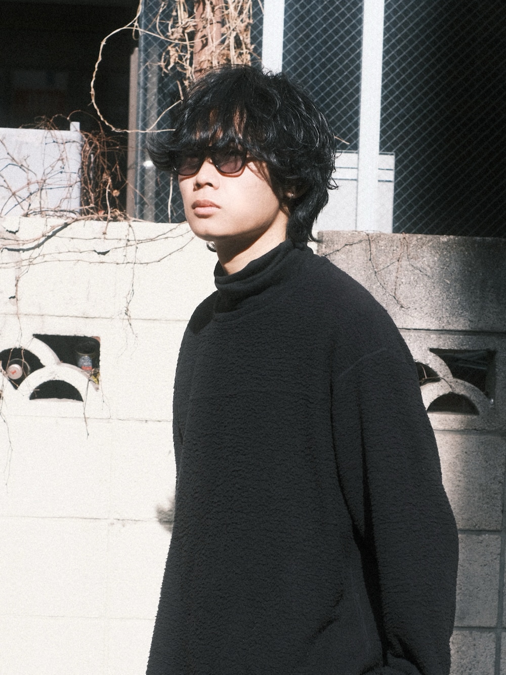 グレー系のニット/セーター、ブラック系のTシャツ/カットソー、ブルー系のデニムパンツを着用したメンズの冬コーディネートの2枚目の写真