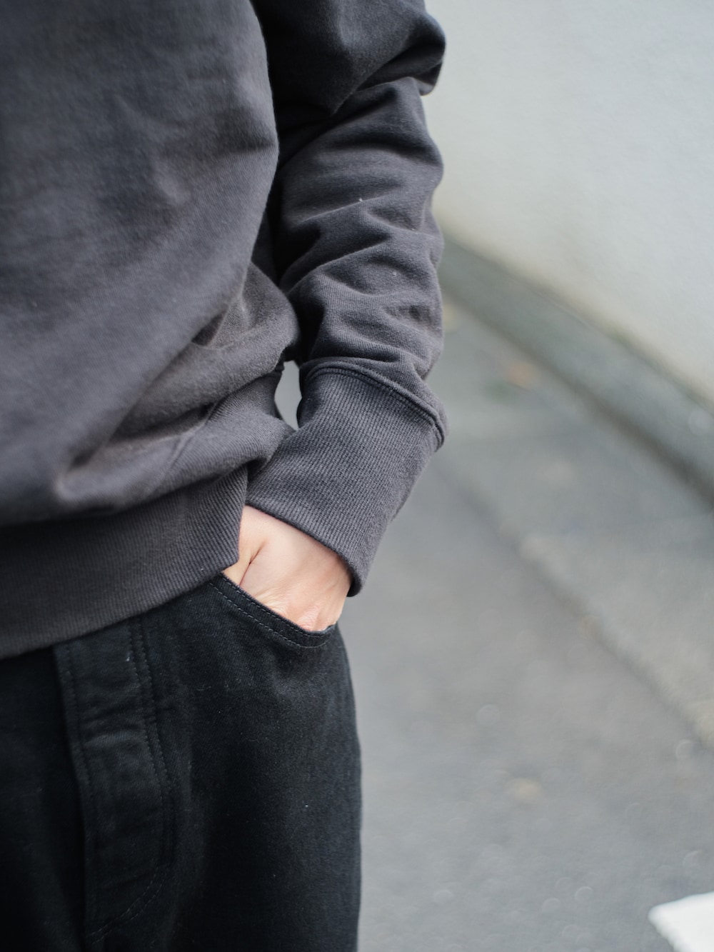 ブラック系のスウェット、ブラック系のデニムパンツ、ブラック系のドレスシューズを着用したメンズの春コーディネートの4枚目の写真