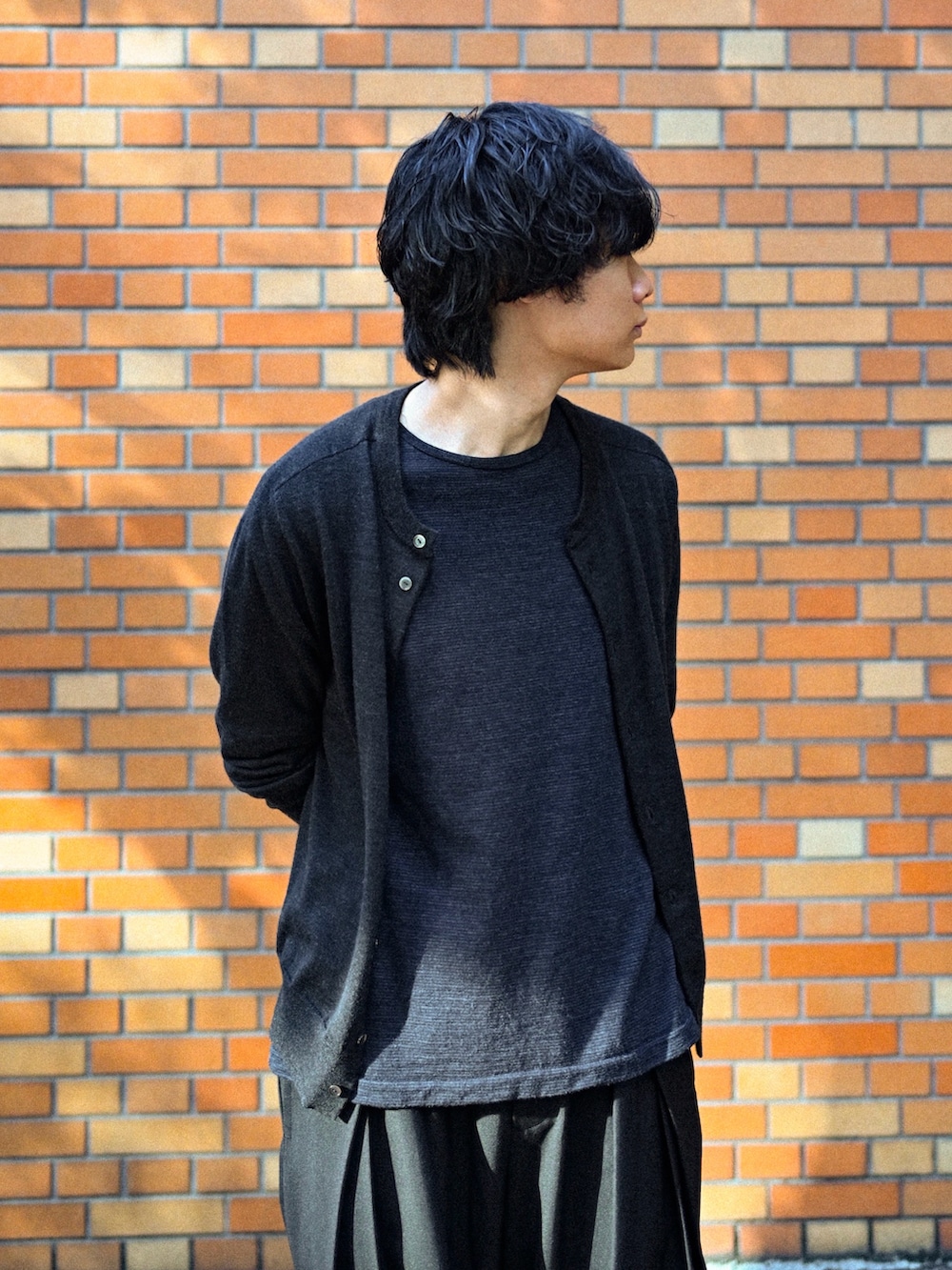 ブラック系のブーツ、ブラック系のスラックス、ブラック系のTシャツ/カットソーを着用したメンズの春コーディネートの3枚目の写真