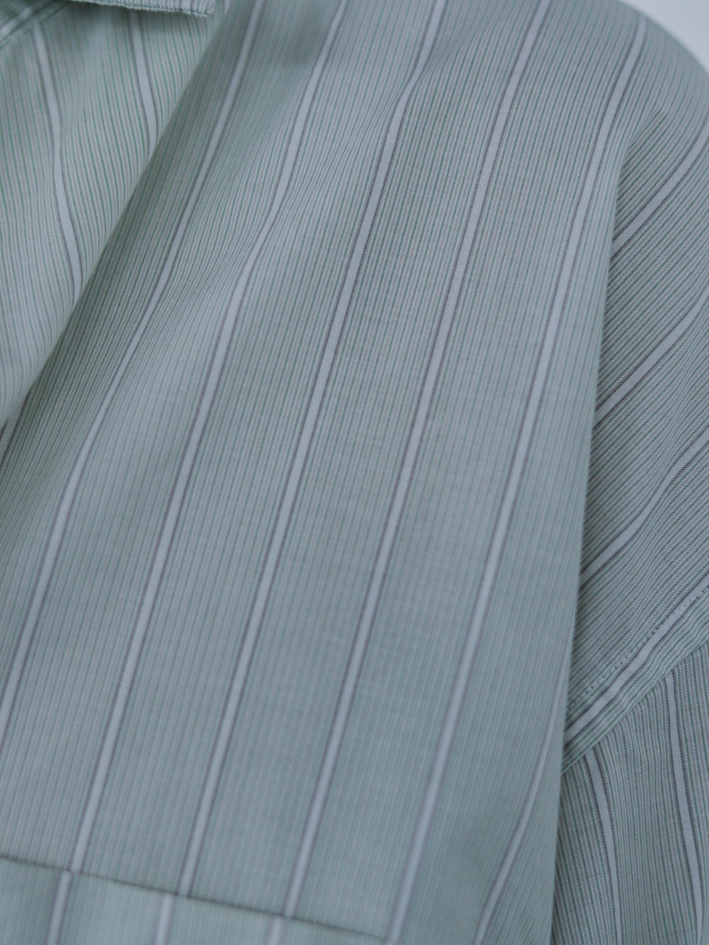 グレー系のカーゴパンツ、グリーン系のシャツ/ブラウス、グレー系のタンクトップを着用したメンズの夏コーディネートの2枚目の写真