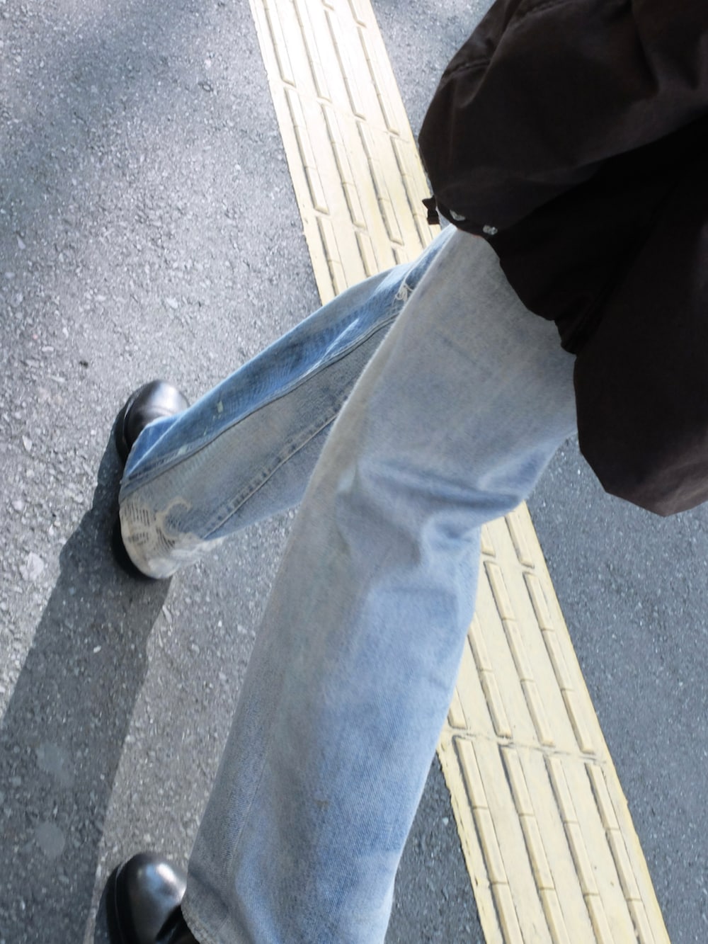 ブラウン系のブルゾン、ブルー系のデニムパンツ、ブラック系のブーツを着用したメンズの冬コーディネートの2枚目の写真