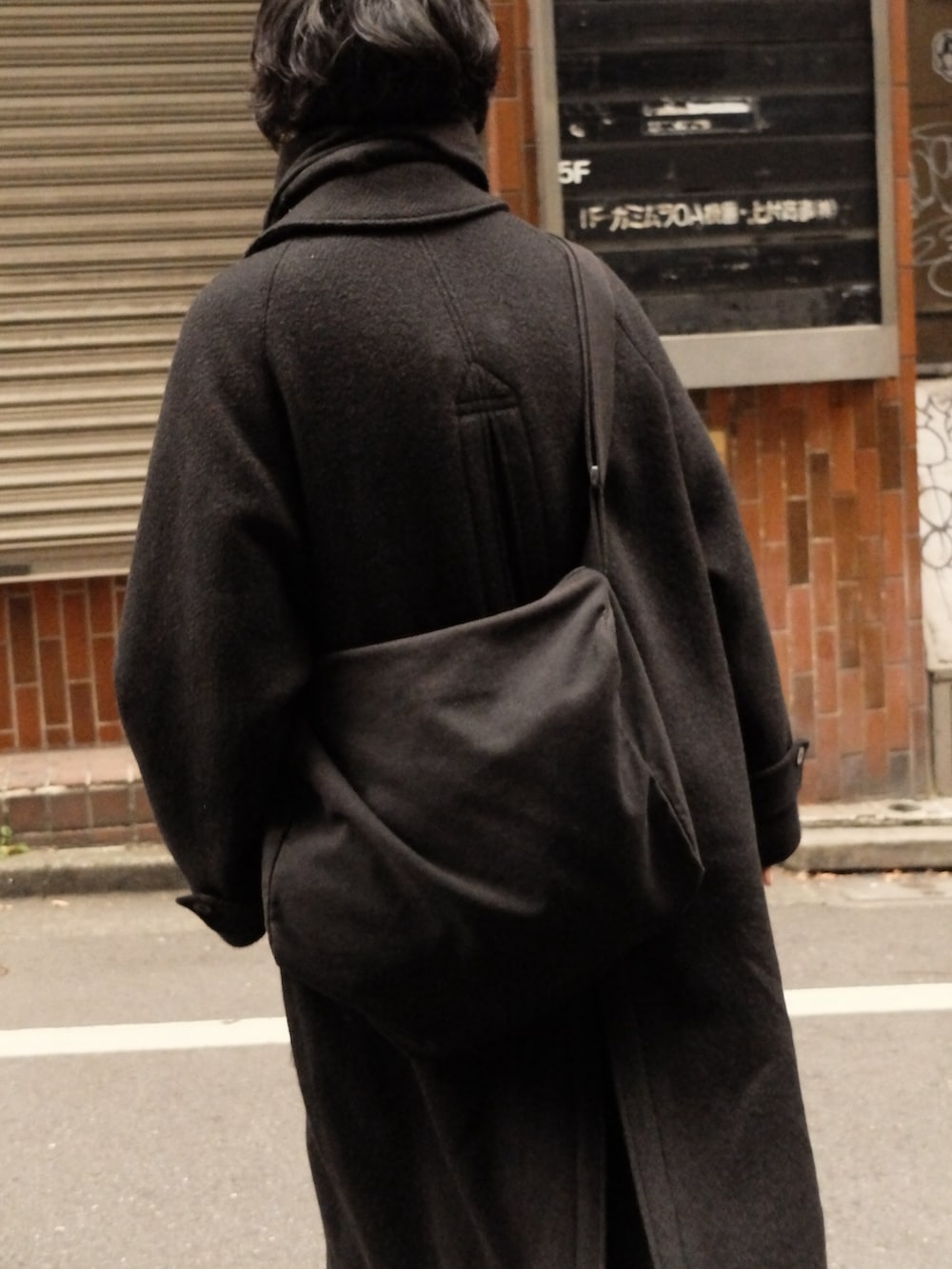 ブラック系のその他アウター、ブラック系のブーツ、ブラック系のデニムパンツを着用したメンズの冬コーディネートの4枚目の写真